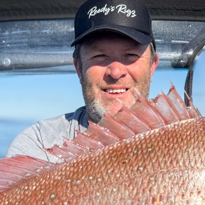 Reedy holding a snapper, founder of Reedy's Rigs and BayCast